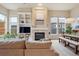Bright living room featuring a fireplace, built-in shelving, and large windows with natural light at 9580 E 5Th Ave, Denver, CO 80230