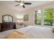Well-lit main bedroom with large windows, a ceiling fan, and wood dresser and mirror at 9580 E 5Th Ave, Denver, CO 80230