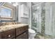 Bathroom featuring granite countertops, dark brown cabinets, and a tiled shower at 9783 Zephyr Dr, Broomfield, CO 80021