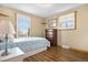 Comfortable bedroom showcasing two windows with shutters, a dresser, and hardwood floors at 9783 Zephyr Dr, Broomfield, CO 80021