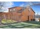 Back of a two-story wood building with an exterior door, surrounded by an artificial turf yard and a wooden pergola at 9783 Zephyr Dr, Broomfield, CO 80021