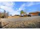 Exterior view of a property featuring a large gravel area and several outbuildings under a blue sky at 9783 Zephyr Dr, Broomfield, CO 80021