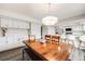 Open dining room with a large wooden table, stylish light fixture, and access to the kitchen at 3964 S Yosemite St, Denver, CO 80237