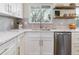 White kitchen cabinets with quartz countertops and stainless steel appliances at 7649 E Amherst Ave, Denver, CO 80231