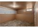 Unfinished basement area with tile floor, storage cabinets, small window and base trim at 4125 Pierce St, Wheat Ridge, CO 80033