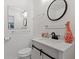 Bathroom features modern fixtures, a white vanity, and a sleek round mirror at 4125 Pierce St, Wheat Ridge, CO 80033