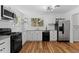 Bright kitchen featuring stainless steel appliances, white cabinets, and hardwood flooring at 4125 Pierce St, Wheat Ridge, CO 80033