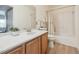 Bathroom features a single sink vanity with wood cabinets and tub-shower combo at 3847 Mossy Rock Dr # 104, Highlands Ranch, CO 80126
