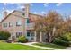 Tan two-story condo with private balcony and mature landscaping under a blue sky at 3847 Mossy Rock Dr # 104, Highlands Ranch, CO 80126