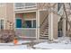 Inviting ground floor townhouse entrance with a small porch decorated with a festive Christmas tree at 3847 Mossy Rock Dr # 104, Highlands Ranch, CO 80126