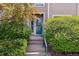 Inviting front entrance with glass paneled door and lush green bushes at 3847 Mossy Rock Dr # 104, Highlands Ranch, CO 80126
