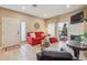 Bright living room with a modern red sofa, fireplace, and an open doorway to the outside at 3847 Mossy Rock Dr # 104, Highlands Ranch, CO 80126