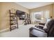Neutral-toned living room with bookshelves and modern media setup at 3847 Mossy Rock Dr # 104, Highlands Ranch, CO 80126