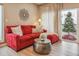 Stylish living room showcasing a comfortable red sofa and sleek metal coffee table by a window at 3847 Mossy Rock Dr # 104, Highlands Ranch, CO 80126