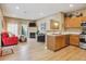 Well-lit living area flowing into the kitchen, featuring wood-look floors and modern appliances at 3847 Mossy Rock Dr # 104, Highlands Ranch, CO 80126