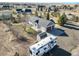 Aerial view of rural property, featuring a gray home with a three-car garage, a camper, and an outbuilding at 56450 E 40Th Ave, Strasburg, CO 80136