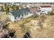 The aerial view shows a backyard of the home with a lawn and the surrounding landscape in a rural area at 56450 E 40Th Ave, Strasburg, CO 80136