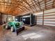 Interior of barn, showing green tractor with loader and black trailer at 56450 E 40Th Ave, Strasburg, CO 80136