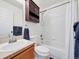 Bathroom featuring a vanity with sink, toilet, and a shower/tub with white tiled walls at 56450 E 40Th Ave, Strasburg, CO 80136