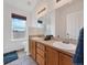 Bright bathroom with a double sink vanity, large mirror, tile floors, and window over looking a field at 56450 E 40Th Ave, Strasburg, CO 80136