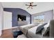 Bedroom with wood floors, large window, ceiling fan, and a calming accent wall at 56450 E 40Th Ave, Strasburg, CO 80136