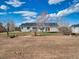 Backyard view of the house, displaying the spacious lot and back entrance with a red door at 56450 E 40Th Ave, Strasburg, CO 80136
