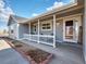 Charming covered front porch with white railings and brick garden edging detail at 56450 E 40Th Ave, Strasburg, CO 80136