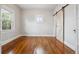 Bedroom features hardwood floors, a sliding barn door, and natural light at 4046 S Bannock St, Englewood, CO 80110