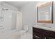 Clean bathroom featuring a shower-tub, white tile, granite counters, and wooden mirror trim at 6700 Clay St, Denver, CO 80221