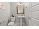 Bathroom features a pedestal sink, framed mirror, decorative accents, and a neutral color palette at 6700 Clay St, Denver, CO 80221