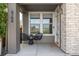 Inviting front porch with seating, a stacked stone accent wall, and views of the neighborhood at 6700 Clay St, Denver, CO 80221