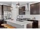 Modern kitchen features dark cabinetry, a center island with seating, and stainless steel appliances at 6700 Clay St, Denver, CO 80221
