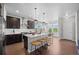 Spacious kitchen featuring dark cabinetry, a center island with seating, and stainless steel appliances at 6700 Clay St, Denver, CO 80221