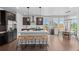 Modern kitchen featuring a large island with seating, stainless steel appliances, and hardwood floors at 6700 Clay St, Denver, CO 80221