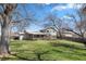 Expansive backyard featuring mature trees, a covered deck, and a well-maintained lawn perfect for outdoor activities at 7181 Beech St, Arvada, CO 80004