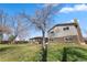 Beautifully landscaped backyard with a spacious lawn, mature trees, and a charming covered patio at 7181 Beech St, Arvada, CO 80004