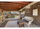 Relaxing covered patio featuring brick wall, outdoor seating, and yard access at 7181 Beech St, Arvada, CO 80004