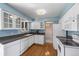 Charming kitchen features white cabinetry, updated appliances, and hardwood floors at 7181 Beech St, Arvada, CO 80004
