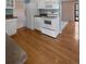 Spacious kitchen featuring white appliances and hardwood flooring at 7181 Beech St, Arvada, CO 80004