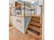 Staircase leading to the kitchen with natural light and beautiful banister at 7181 Beech St, Arvada, CO 80004