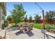 Outdoor patio featuring a dining table with chairs, string lights, and manicured landscaping at 5328 Potentilla St, Brighton, CO 80601