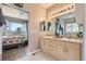 Bathroom featuring dual sinks with plenty of counterspace and natural light from a window at 5328 Potentilla St, Brighton, CO 80601