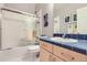 Bathroom with tub and shower, blue tiled counter, and bright lighting at 5328 Potentilla St, Brighton, CO 80601