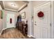 Welcoming entryway with hardwood floors, a console table and coat rack, and a front door at 5328 Potentilla St, Brighton, CO 80601