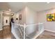 Upstairs hallway with a view of the entryway and white railing at 5328 Potentilla St, Brighton, CO 80601