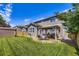 The manicured lawn and outdoor dining space enhance the appeal of this home's backyard at 12631 Glencoe St, Thornton, CO 80241