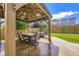 Outdoor dining space with a table and chairs set under a covered patio in a fenced-in yard at 12631 Glencoe St, Thornton, CO 80241