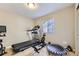 A spare room is equipped with exercise equipment, illuminated by natural light from a side window at 12631 Glencoe St, Thornton, CO 80241