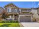 Beautiful two-story home featuring a well-manicured lawn and a two-car garage with stone accents at 12631 Glencoe St, Thornton, CO 80241