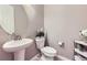 Stylish half-bathroom featuring a pedestal sink, modern fixtures, and neutral wall color at 12631 Glencoe St, Thornton, CO 80241